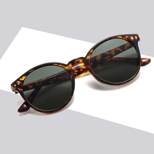 Vintage tortoiseshell round frame sunglasses with dark green lenses and metal rivets