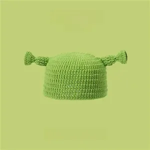 Detailed close-up of green knitted hat featuring unique ogre-style ear decorations