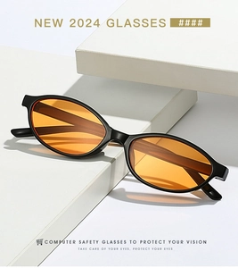 Close-up of retro oval glasses with black frame and orange lenses on a white display