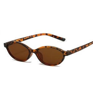 Fashionable tortoise shell oval sunglasses with dark brown lenses for women's street style