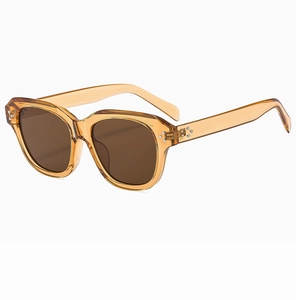 Detail of amber tortoiseshell sunglasses with brown lenses and silver rivets on the frame