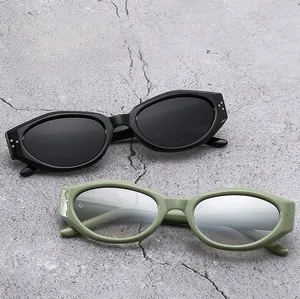Detail view of oval cat eye sunglasses in black and green with decorative rivets
