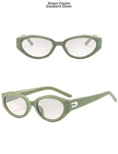 Detail of green cat-eye sunglasses with silver U-shaped metal trim and gradient lenses