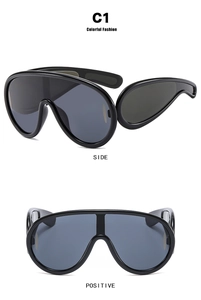 Detail view of large futuristic black wrap sunglasses showing front and side perspectives