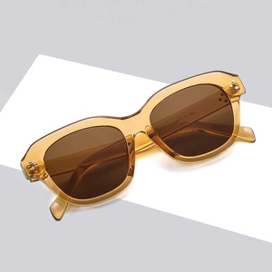 Retro square oversized amber sunglasses with brown lenses on a minimalist grey background