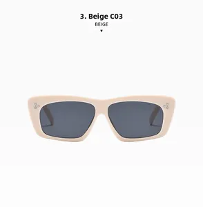 Detail view of beige rectangle sunglasses with silver triple-point rivets and dark grey lenses