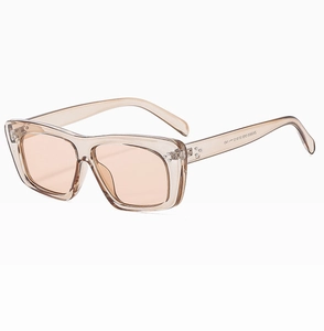 Detail view of champagne resin sunglasses with orange lenses and temple model engraving