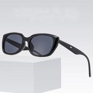 Retro cat-eye sunglasses with black frame and grey lenses on a white display block