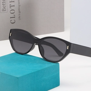 Retro black cat-eye sunglasses with thick frames and dark lenses on a geometric stand