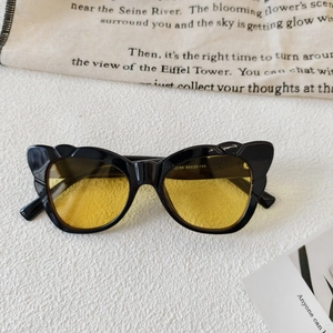 Detail view of butterfly cat-eye sunglasses with yellow lenses and frame specifications