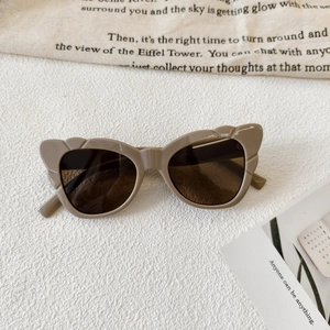Detail of khaki cat eye sunglasses with unique thick frames and stylish cut-out edges