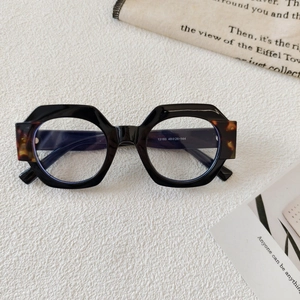 Close-up of geometric round sunglasses with tortoiseshell accents and model dimensions