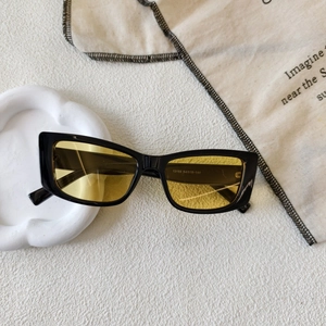 Detailed macro view of square retro sunglasses with gold lenses and silver stud accents