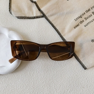 Detail view of vintage square sunglasses with brown transparent frames on soft aesthetic background