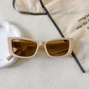 Detailed view of beige square frame sunglasses with brown lenses on a white minimalist background