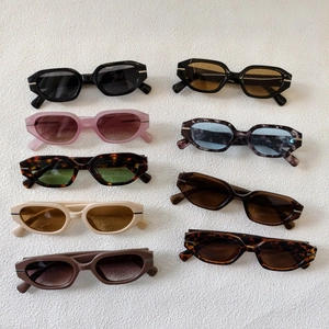 Collection of nine colorful retro oval sunglasses with vintage frames and metal accents