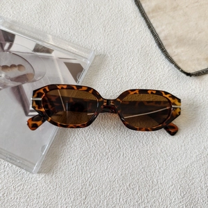 Close-up of retro hexagonal tortoiseshell sunglasses with dark brown lenses and wide frame
