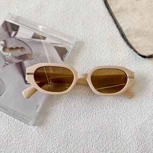 Detail of vintage geometric sunglasses with cream frames and silver metal hinges