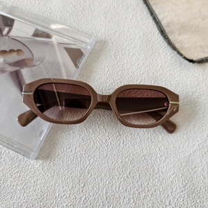 Detail of vintage oval brown sunglasses featuring gradient lenses and metal temple accents