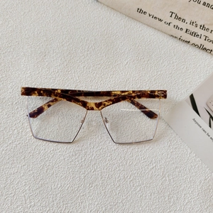 Detail of tortoise shell browline frame with gold metal lower rim and clear lenses