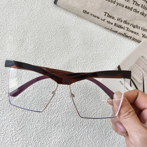 Close-up of tortoise shell browline frames with geometric gold metal rims and clear lenses