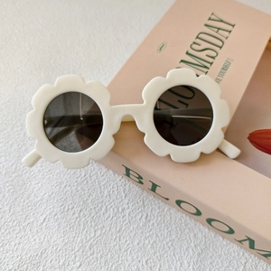 Dettaglio di occhiali da sole bianchi a forma di fiore per bambini con lenti scure rotonde