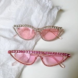 Lunettes de soleil cat-eye roses surdimensionnées avec strass sur fond blanc