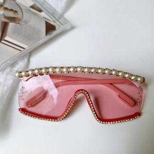 Détail de lunettes de soleil roses dégradées avec perles et accents de strass