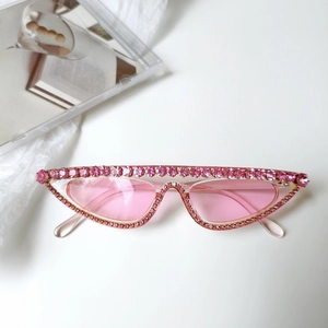 Vue détaillée de lunettes de soleil œil-de-chat roses ornées de strass brillants