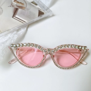 Détails de lunettes de soleil œil-de-chat roses avec monture luxueuse ornée de strass