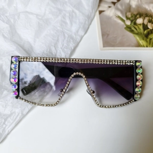 Detail of oversized flat top sunglasses with rhinestone frame and purple gradient lenses