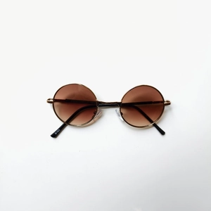 Vue détaillée des lunettes de soleil rondes en métal doré avec verres dégradés marron B183