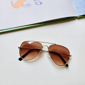Detail of kids pilot sunglasses with gold metal frame and brown gradient lenses