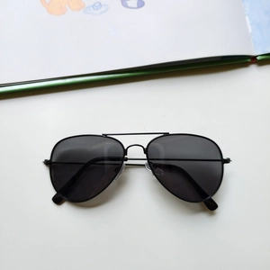 Detail view of children's black aviator sunglasses with metal frame and dark lenses
