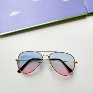 Close-up of kids aviator sunglasses featuring blue pink gradient lenses and gold metal frames