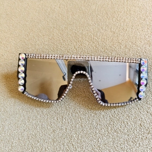 Détail de lunettes de soleil oversize à dessus plat avec strass étincelants et verres dégradés