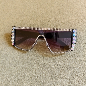 Détail de lunettes de soleil masque oversize avec strass et verres dégradés violets