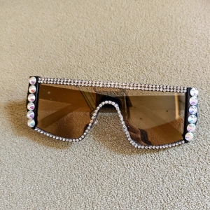 Détail de lunettes de soleil oversize avec strass et grandes gemmes AB colorées