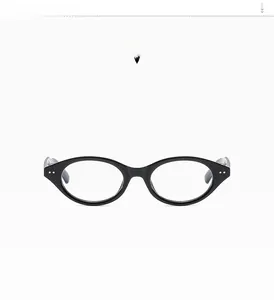 Macro shot of glossy black oval eyeglass frames with silver rivet accents for a retro look