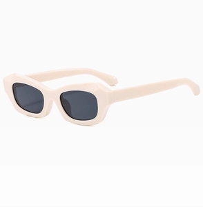 Gros plan sur des lunettes de soleil œil-de-chat beiges avec monture géométrique épaisse