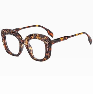 Close-up of tortoise shell oval sunglasses with vintage hollow lattice frame detail