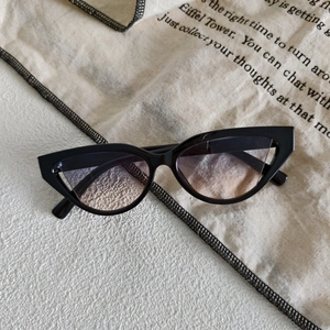 Detail shot of vintage black cat-eye sunglasses with gradient lenses and a sleek finish