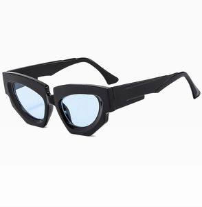 Close-up of geometric cat-eye sunglasses with thick black frames and light blue lenses