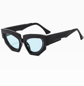 Detail view of bold black cat-eye sunglasses with light blue lenses and angular frame
