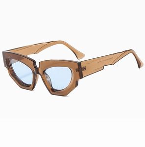 Detail of tea-colored geometric cat-eye sunglasses with light blue lenses and inner specs