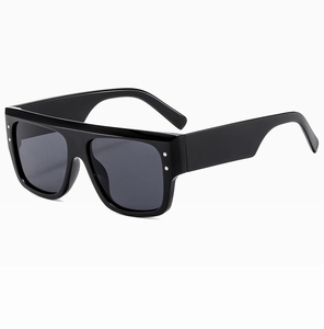 Detail of flat top black sunglasses with silver dot rivets and dark lenses