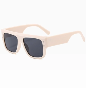 Detail view of cream oversized square sunglasses with metal rivets and dark lenses