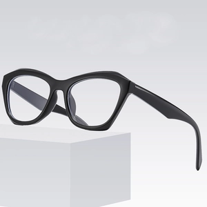Oversized geometric cat-eye glasses with black frames on a minimalist white cube pedestal
