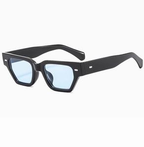 Détail de lunettes de soleil rétro à monture noire, verres bleus et rivets métalliques