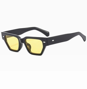 Détail de lunettes de soleil rétro montrant monture noire et verres jaunes à rivets